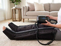 Elevate Performance Systems Apex Elite recovery boots on a person sitting on a living room floor with touch screen unit