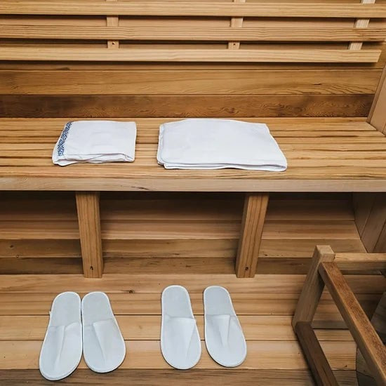 Elevate Performance Systems Vista wood fired sauna interior featuring Canadian red cedar benches and white slippers.