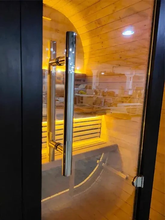 Elevate Performance Systems Noir Cube Sauna interior view showing warm LED lighting, alder wood benches, and glass door