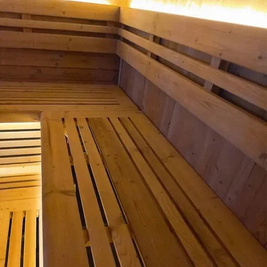 Elevate Performance Systems Noir Cube Sauna interior featuring L-shaped alder wood benches and warm LED lighting.
