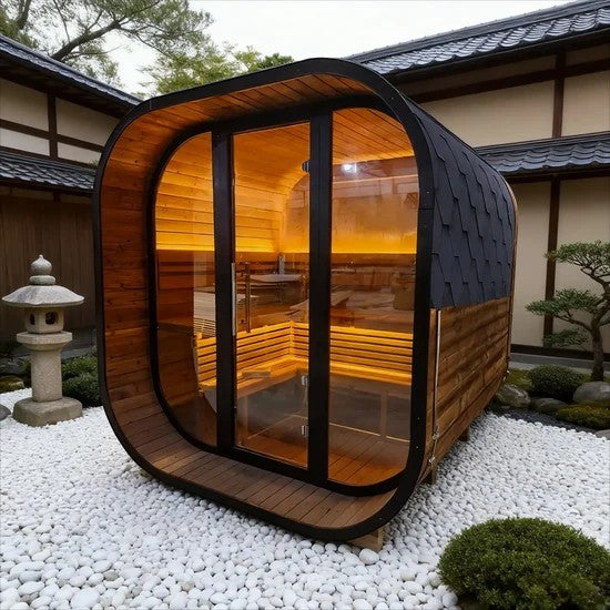 Elevate Performance Systems Noir Cube Sauna with black exterior, glass front, and warm LED interior lighting in a garden