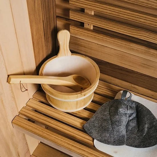 Elevate Performance Systems cedar barrel sauna accessories including a wooden bucket, ladle, and grey felt sauna hat.