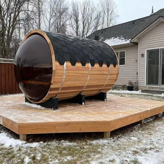 Elevate Performance Systems Vista wood-fired barrel sauna with panoramic glass in a snowy backyard setting.