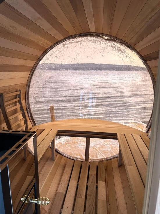 Elevate Performance Systems Vista wood-fired barrel sauna interior with panoramic glass window overlooking a lake.