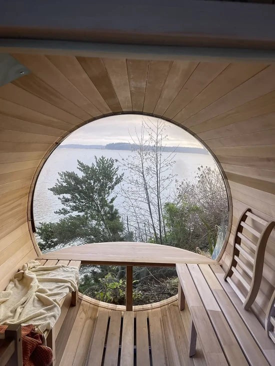 Elevate Performance Systems Vista wood-fired sauna interior with panoramic circular window overlooking a lake view